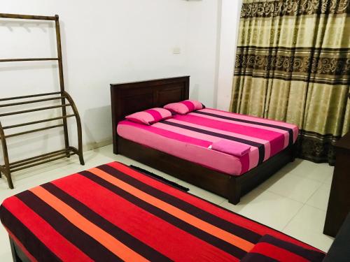 a bedroom with two beds and a red rug at Relation Hotel in Colombo