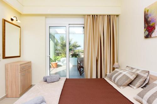 een slaapkamer met een groot bed en een balkon bij Elli Garden View - Spacious Fully Equipped Apartment in Kremasti