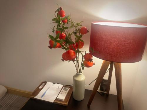 a table with a lamp and a vase with fruit at Nhà mình Homestay in Rach Gia
