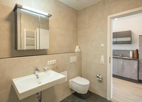 a bathroom with a sink and a toilet at SweetHome - Poing Apartments in Poing