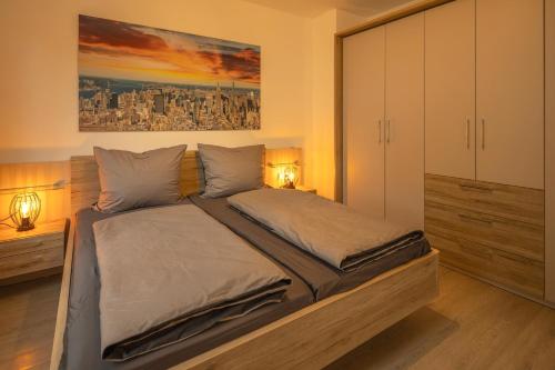 a bedroom with a large bed with two lamps at SweetHome - Poing Apartments in Poing