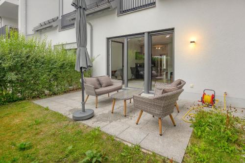 a patio with two chairs and an umbrella at SweetHome - Poing Apartments in Poing