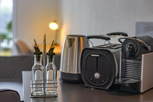 a counter top with a toaster and bottles on it at SweetHome - Poing Apartments in Poing