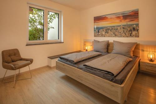 a bedroom with a large bed and a chair at SweetHome - Poing Apartments in Poing