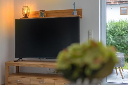 a flat screen tv sitting on a wooden stand at SweetHome - Poing Apartments in Poing
