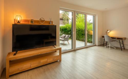 a living room with a large flat screen tv at SweetHome - Poing Apartments in Poing