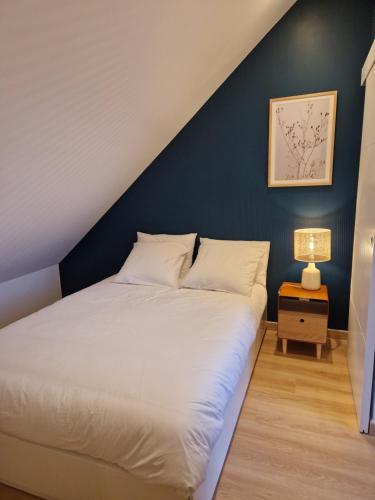 Schlafzimmer mit einem Bett mit blauer Wand in der Unterkunft LE PATUREAU Gite en campagne avec terrasse Carquefou - Nantes in Carquefou