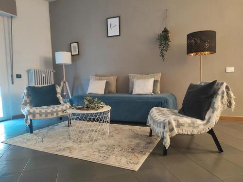 a living room with a blue couch and chairs at B&B Royal Prato in Prato