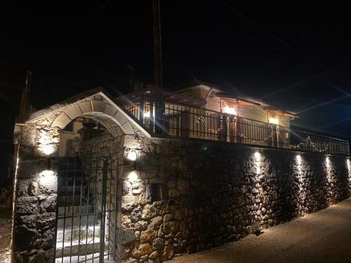 a stone wall with lights on it at night at Methydrion Country House in Vytina