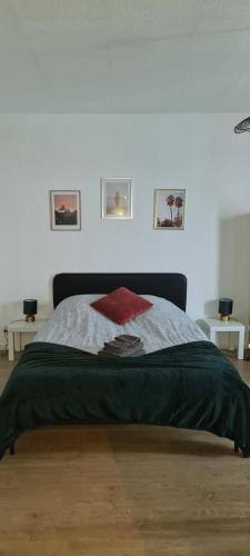 um quarto com uma cama com um cobertor vermelho em Studio KAAN avec terrasse 5mn Basel Airport em Saint-Louis