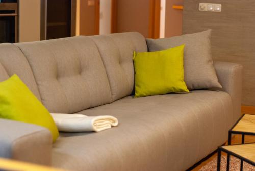 un sofá con 2 almohadas amarillas en Vilmsi 44 cozy 85m2 apartment with sauna in Kadriorg en Tallin