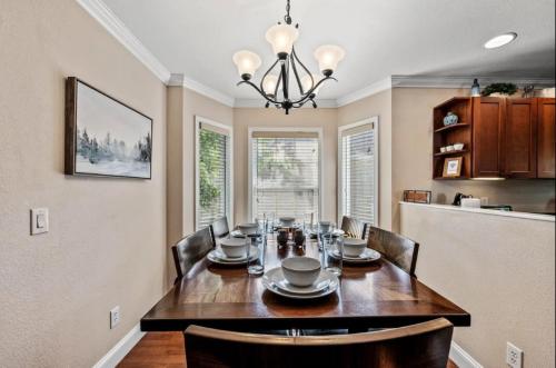 a dining room with a table with chairs and a chandelier at Creekside Cottage*Hot Tub*Entire Home-Pigeon Forge in Pigeon Forge