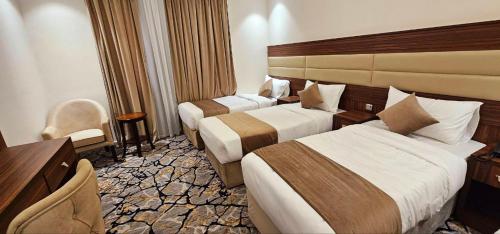 Un pat sau paturi într-o cameră la EWG Al Mashaer Hotel