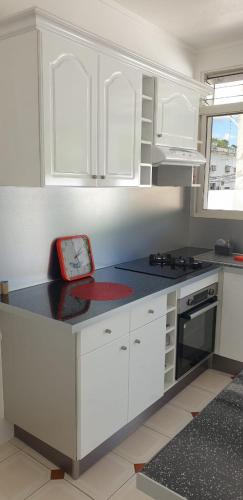 a kitchen with white cabinets and a counter top at COSY Tamarins 2 plage à quelques mètres à pied in Sainte-Anne