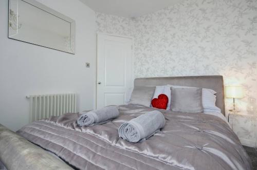 een bed met kussens en een rood hart erop bij Seaview Regency Apartment With Private Parking in Brighton & Hove