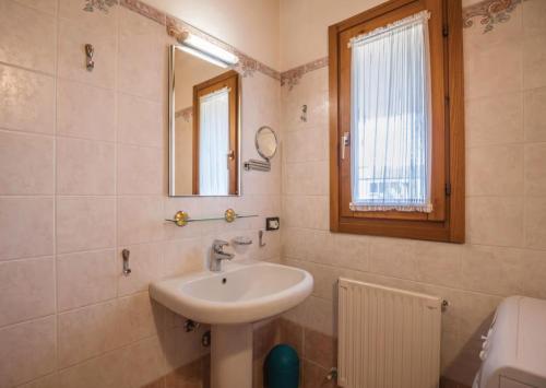 La salle de bains est pourvue d'un lavabo et d'un miroir. dans l'établissement Apt Gardasee Lazise Cola, à Colà