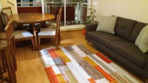 a living room with a couch and a table at Apartamento full equipado in Temuco