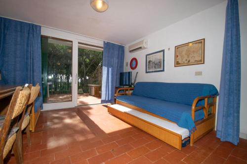 a bedroom with a bed with a blue blanket at Condominio Dunelba in Marina di Campo