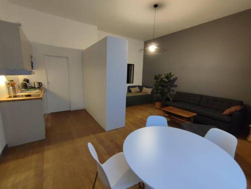un salon avec une table blanche et un canapé dans l'établissement Apartment in the heart of the Chartrons, à Bordeaux
