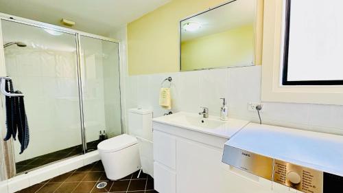 a bathroom with a toilet and a sink and a shower at Three Monkeys Residence in Kellyville