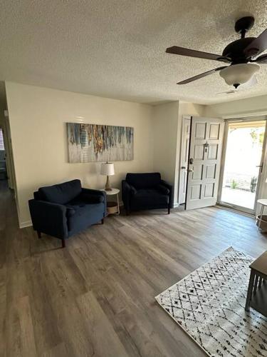 a living room with two chairs and a ceiling fan at Just like home! in Huntsville