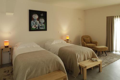- une chambre avec deux lits et une chaise dans l'établissement Gerês - Leiras do Tempo - Cottage Tomadinha 2, à Terras de Bouro