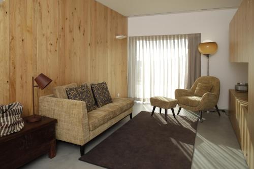 - un salon avec un canapé et une chaise dans l'établissement Gerês - Leiras do Tempo - Cottage Tomadinha 2, à Terras de Bouro