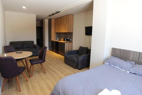 1 dormitorio con 1 cama, mesa y sillas en Roshka Apartment 108, en Gudauri