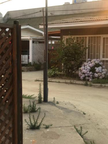 uma casa com uma cerca e flores à frente dela em Se arrienda casa Reñaca Bajo em Viña del Mar