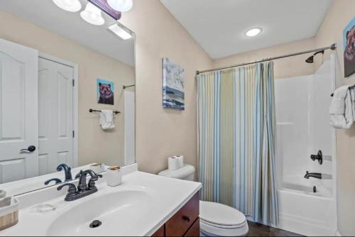 a bathroom with a sink and a toilet and a shower at Creekside Cottage*Hot Tub*Entire Home-Pigeon Forge in Pigeon Forge