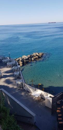 - un groupe de chaises assises sur la plage près de l'eau dans l'établissement Altamarea, à Gênes