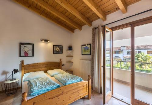 a bedroom with a bed and a balcony at Apt Gardasee Lazise Cola in Colà di Lazise