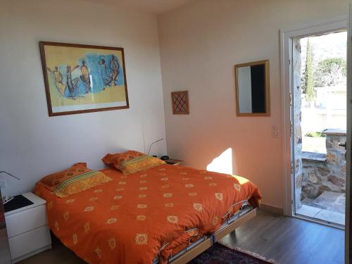 a bedroom with a bed with orange sheets and a window at Chambre d hote independante dans pigeonnier in Mandelieu-la-Napoule