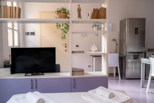 a living room with a flat screen tv on a entertainment center at Casa Moro, monolocale moderno nel centro storico in Crema