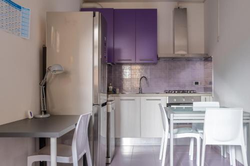 una cucina con armadi viola, tavolo e sedie di Casa Moro a Crema