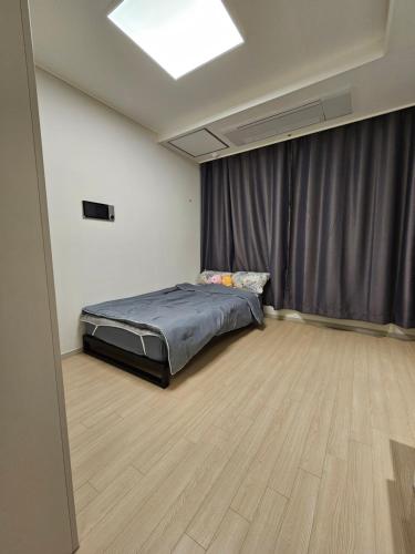 1 dormitorio con cama y cortina en World-cup stadium, New house, full optioned en Goyang