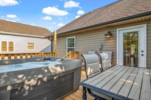 a hot tub on a deck with a table and chairs at Creekside Cottage*Hot Tub*Entire Home-Pigeon Forge in Pigeon Forge