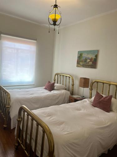a bedroom with two beds and a chandelier at Hotel Boutique & Spa Puerto Natura in Valparaíso