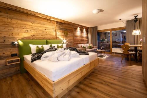 a bedroom with a bed with a wooden wall at Brunnenhof Oberstdorf - Ferienwohnungen mit Hotel Service in Oberstdorf