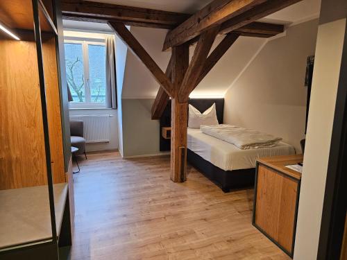 een kleine slaapkamer met een bed en een raam bij Hotel Gasthof Stieglers 