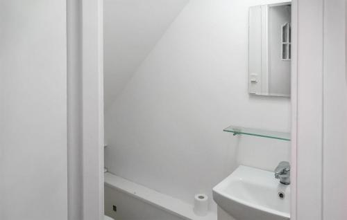 uma casa de banho branca com um lavatório e um espelho em Awesome Home In Pisz With Wi-fi em Pisz