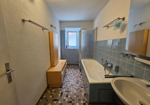 een badkamer met een bad, een wastafel en een bad bij Wohnreich Blaustein Mitte -1A- 2er WG in Blaustein