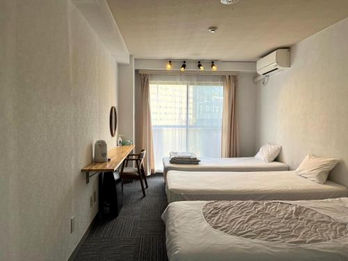 a hotel room with three beds and a desk and a window at CHENDA INTERNATIONAL HOTEL - Vacation STAY 82740v in Seki