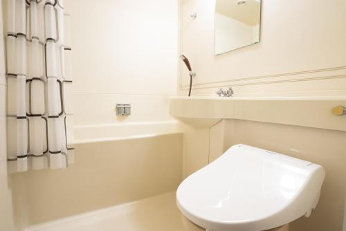 a white bathroom with a toilet and a sink at CHENDA INTERNATIONAL HOTEL - Vacation STAY 82740v in Seki