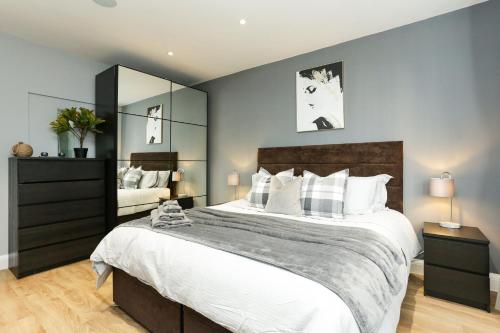 a bedroom with a large bed and a large mirror at The Broadway Beach House with Hot tub in Kent