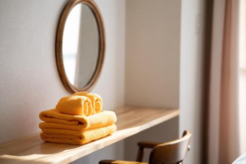 a stack of towels on a shelf with a mirror at CHENDA INTERNATIONAL HOTEL - Vacation STAY 99536v in Seki