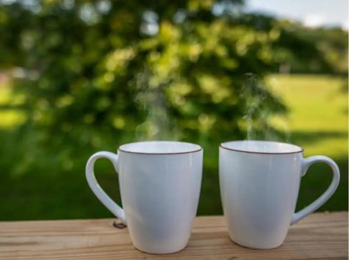 two white cups sitting on top of a table at Creekside Cottage*Hot Tub*Entire Home-Pigeon Forge in Pigeon Forge
