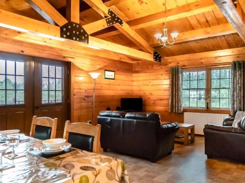 a living room with a table and leather furniture at 4 Lakeview Lodge in Boston