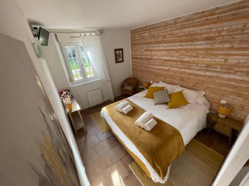 - une chambre avec un grand lit et un mur en bois dans l'établissement VILLA DE CAMPAGNE LES MURAILLES, à Auterive