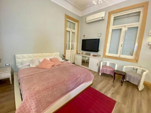 - une chambre avec un grand lit et une télévision dans l'établissement Cozy Room in Garden City for females, au Caire